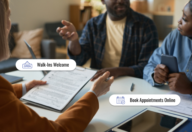 An African-American couple sitting down at the table getting advised by a tax preparer
